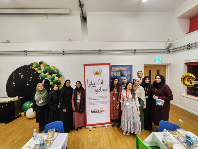 Organisers pose with a "Let's Eat Together" banner.
