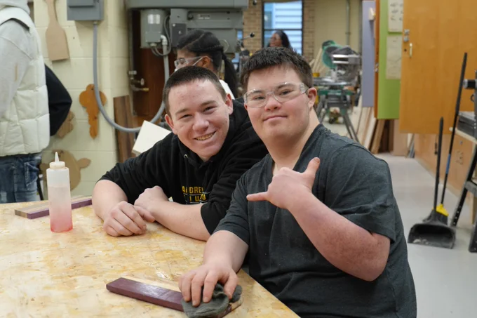 Two VJA students sitting at a workshop table