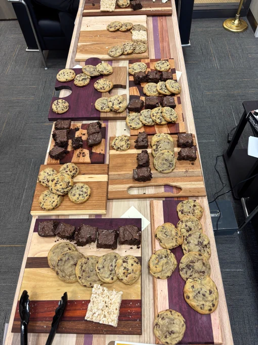 Wooden cutting arranged on a table hold an assortment of chocolate chip cookies and brownies.