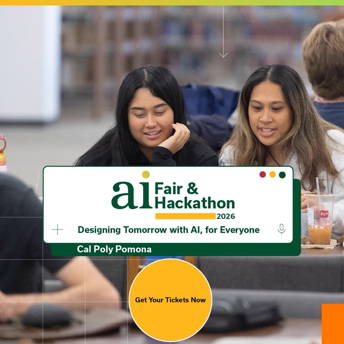 Two students sit at a table looking at their laptops.