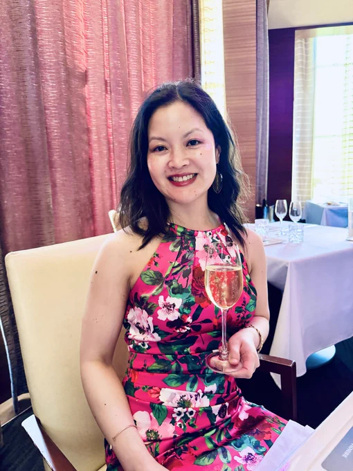 Susan R Lin MW holding glass of champagne
