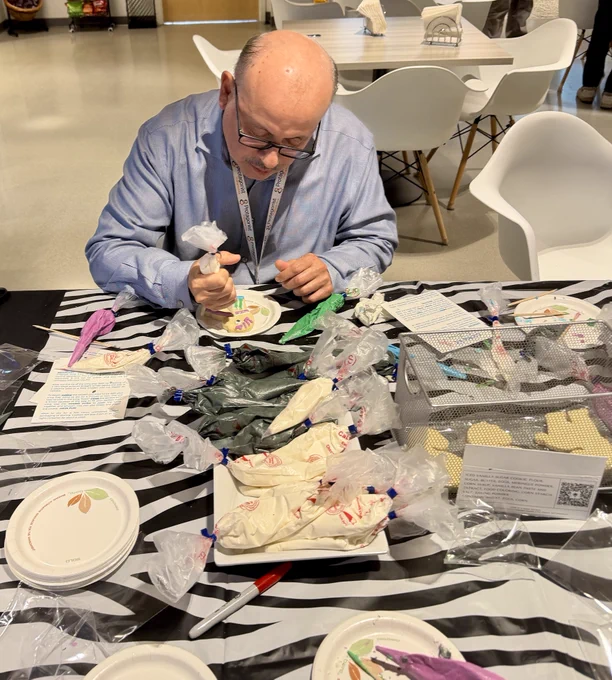 Protagonist employee decorating zebra-shaped cookies with icing