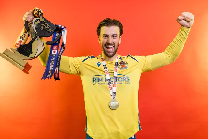Ben Margetson celebrates Barry Town United winning the Nathaniel MG Cup.