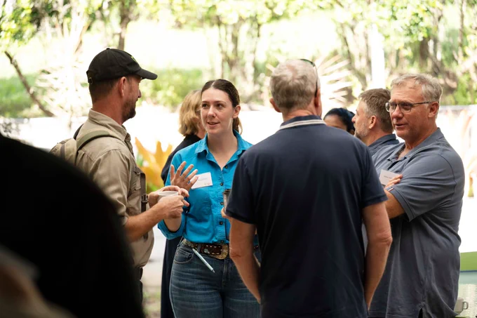 Group of adults engaged in a lively outdoor conversation surrounded by trees and natural light at the AgriFutures Ginger research event and farm tour May 2025.
