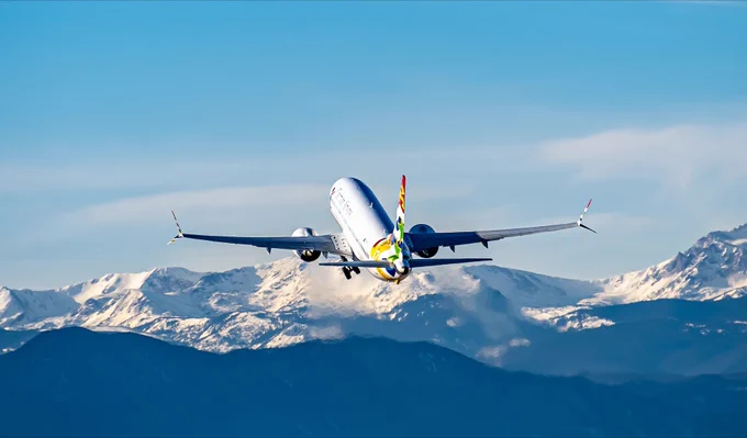 Cayman Airways aircraft departs towards the Rockies at DEN.