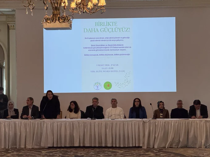 Görselde buluşmanın divanında yer alan kurulun bir görüntüsü var. Arka fonda buluşmanın davetiyesi ekrana yansıtılmış.