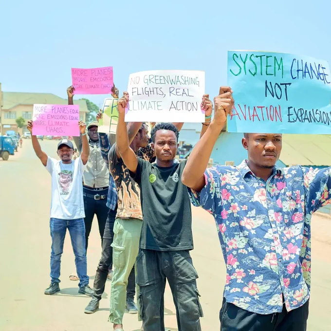 Young people holding placards against aviation and oil