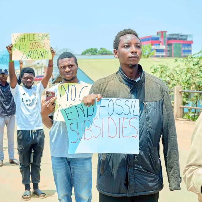 Young people holding placards against aviation and oil