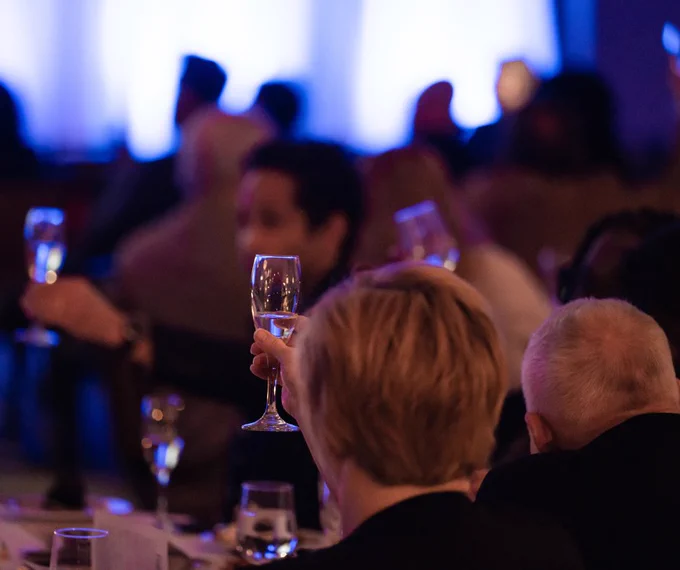 Guests seated at tables raise glasses in a toast during the Pennsylvania Legal Aid Network's Excellence Awards.