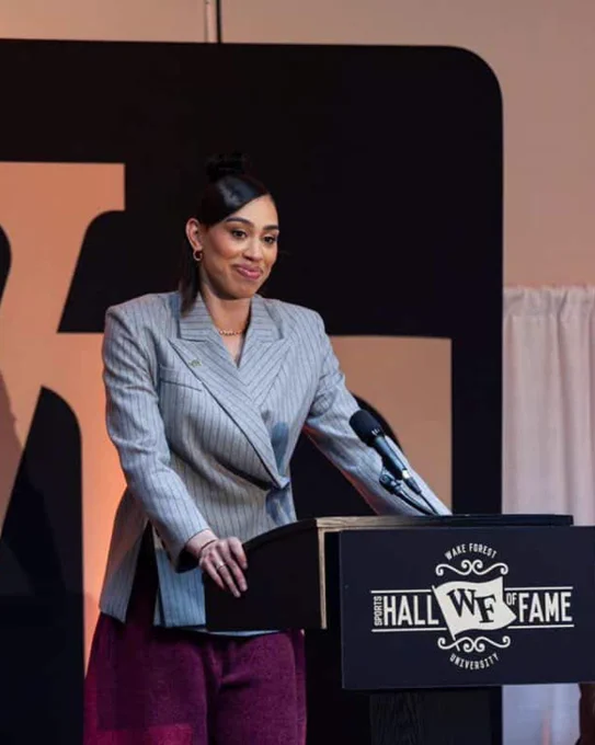 Dearica Hamby smiling at the podium of the Wake Forest Hall of Fame. 