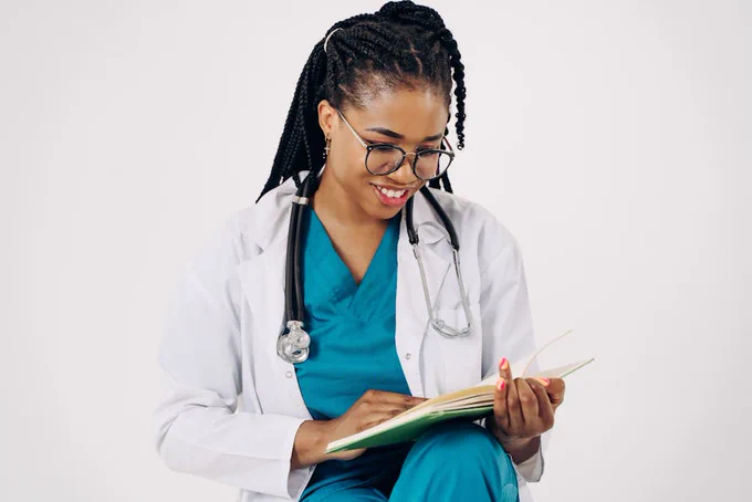 Smiling female doctor with stethoscope reading medical documents.
