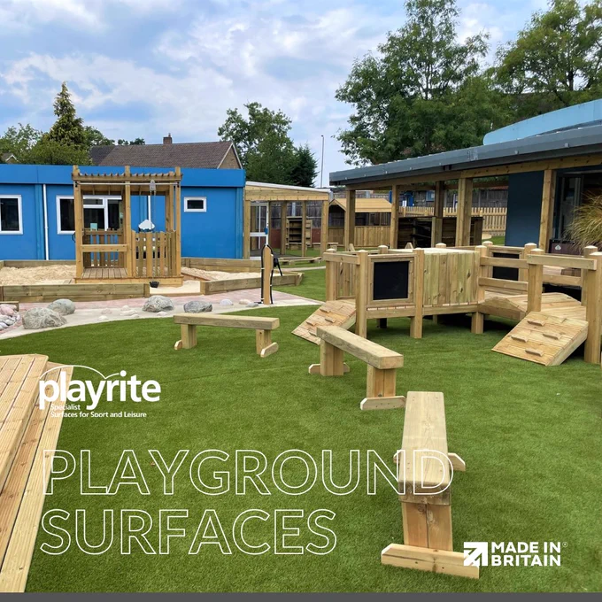 Outdoor playground with wooden climbing structures and artificial grass surface under a partly cloudy sky.