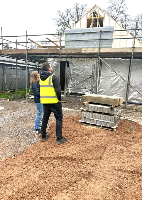 Hannah and WIll looking at the building partially built on a building site