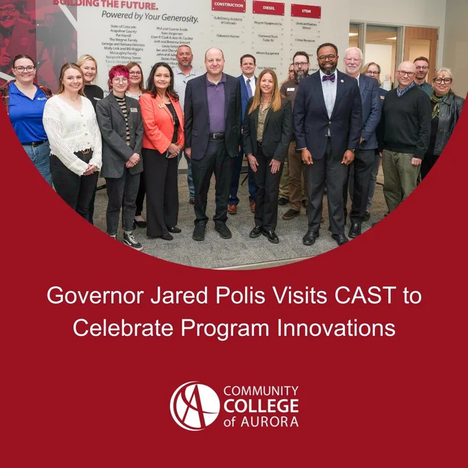 Graphic from Community College of Aurora featuring a group photo of Governor Jared Polis standing with college staff and leaders during a visit at the college, with the headline ‘Governor Jared Polis Visits CAST to Celebrate Program Innovations’ on a red background.