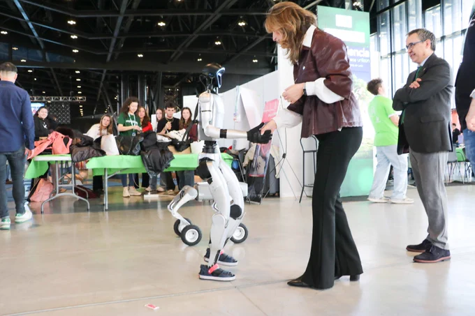 Nuria González, decana de la Universidad de León, interactuando con un robot humanoide en Expociencia