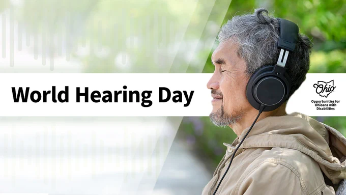 A man smiles while wearing a pair of headphones outdoors. Text, "World Hearing Day." OOD logo.