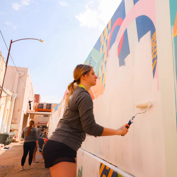 Girl painting wall at big event