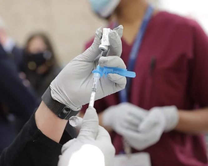 A provider is preparing a COVID-19 vaccine for a patient. 

Credit: Gov Phil Murphy, Edwin J. Torres / Flickr cc