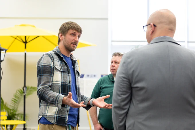 A planner speaking to two other people. 