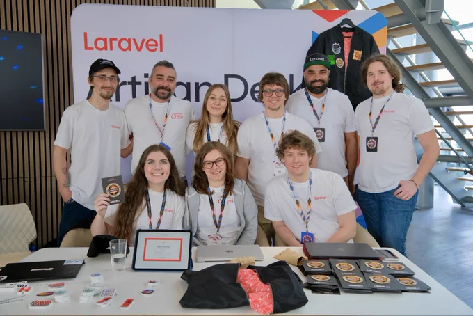 The laravel team posing at the Artisan desk at the Laracon EU conference.
