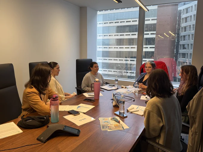 Students sit around table in conference room