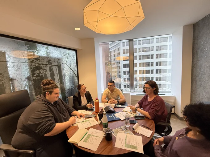 Students sit around table in conference room