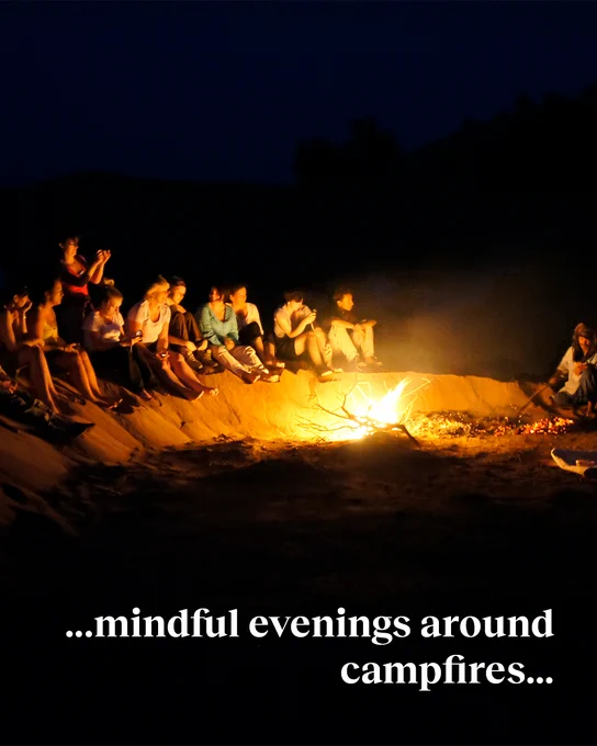 A group of trekkers sat by a bright campfire at night. Text reads: "...mindful evenings around campfires..."