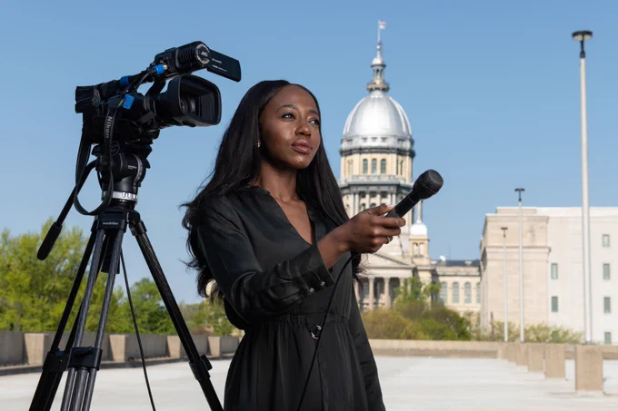 PAR student holding microphone, standing in front of the Illinois Capitol.