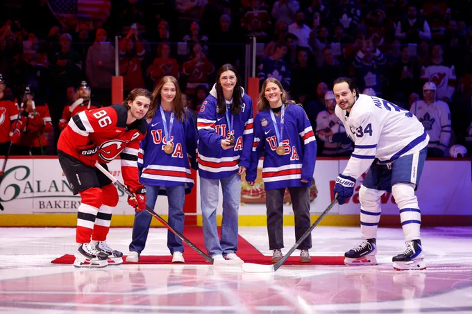 Aerin Frankel, Megan Keller and Haley Winn drop the puck during a ceremonial face-off with Jack Hughes of the Devils and Auston Matthews of the Maple Leafs. 