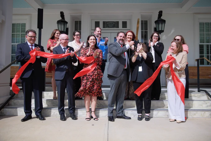 A group of people celebrating a ribbon cutting ceremony.