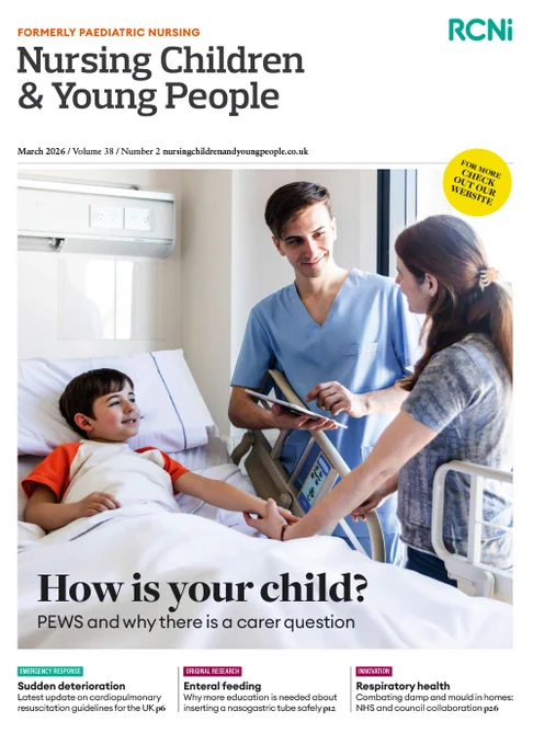 Nurse talks to a parent as she holds the hand of her child who is in a hospital bed.