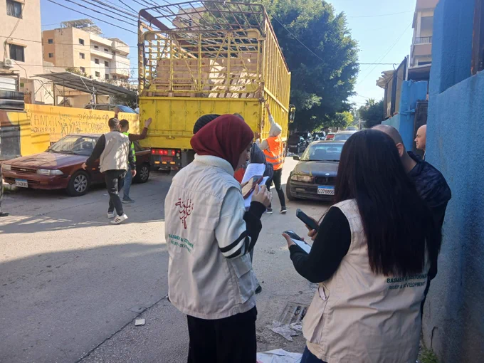 Women writing on clipboards at the roadside. 