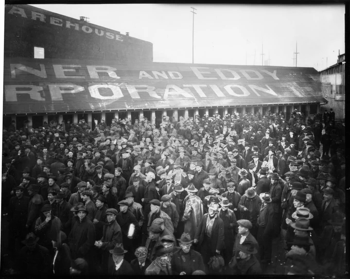 General strike participants leaving shipyards, Seattle, February 1919. This image of workers was taken at the Skinner & Eddy Corporation shipyard located between Dearborn Street and Connecticut Street (now Royal Brougham Way). The nitrate photo shows signs of deterioration on some light parts of the image. 