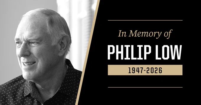 Black-and-white photo of a person smiling, wearing a patterned shirt. Adjacent text reads "In Memory of Philip Low 1947-2026" on a black and gold background.