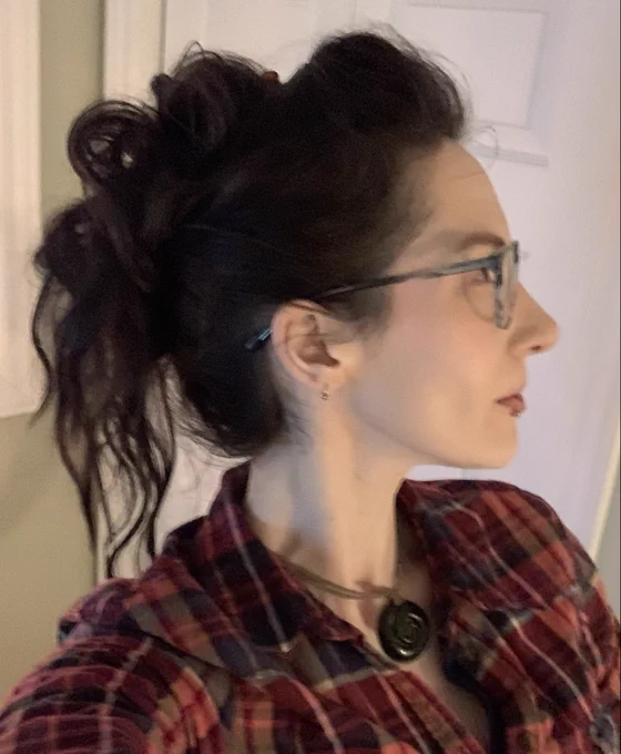 Profile view selfie with messy up-do forming a loose row of spikes like a cartoon dinosaur