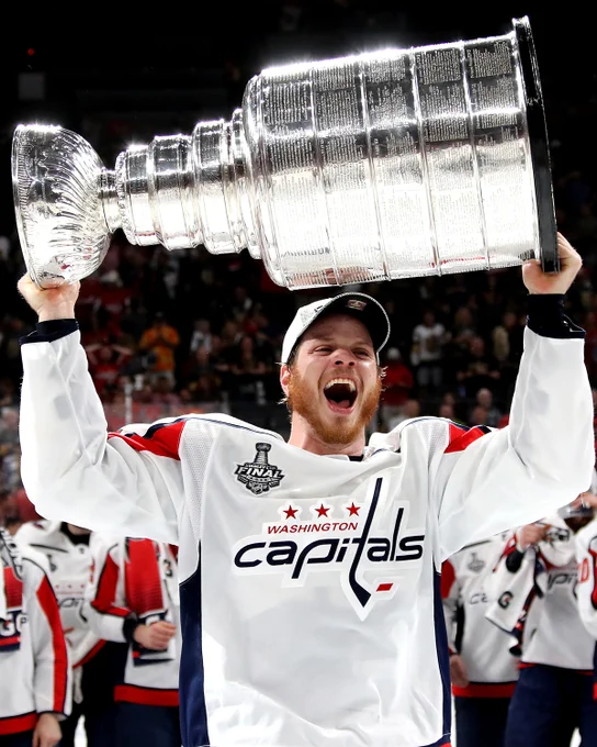 Photo of John Carlson lifting the Stanley Cup in 2018.