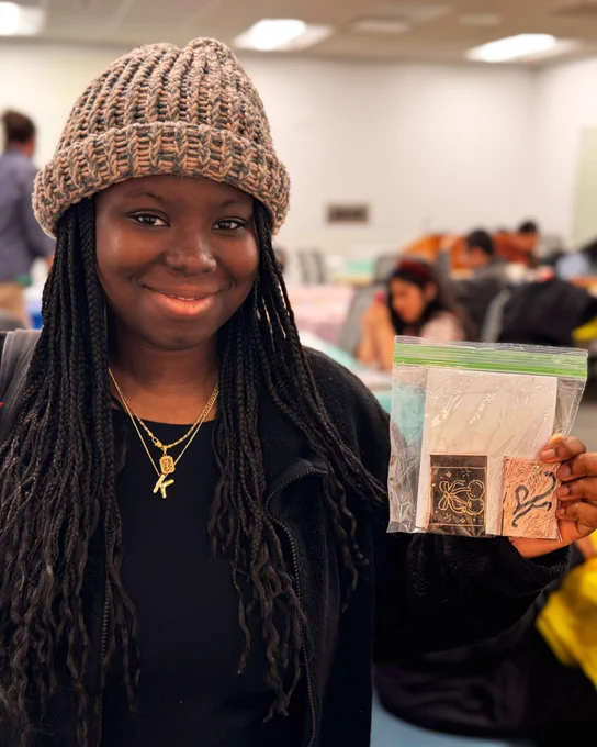A UB student proudly displays completed stamps
