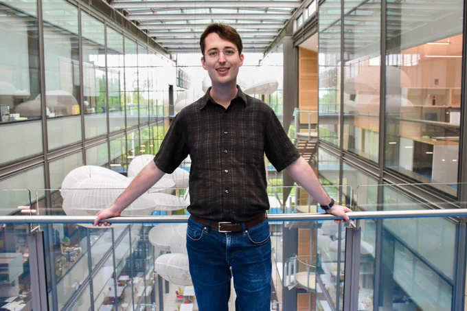 Full-color image of Postdoc Jeremy Owen standing on one of the interior bridges at Frick Lab. (Photo: Mahrad Saghafi)