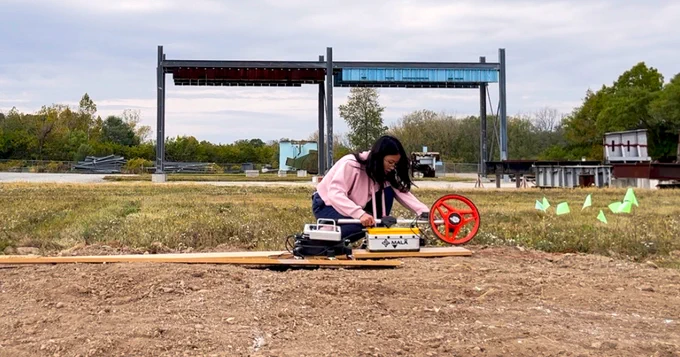  A doctoral candidate in civil engineering, conducts a preliminary field test of a ground-penetrating radar system on an uneven surface.