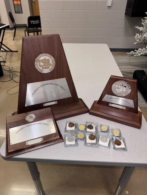 Table with UIL medals and plaques won at contest