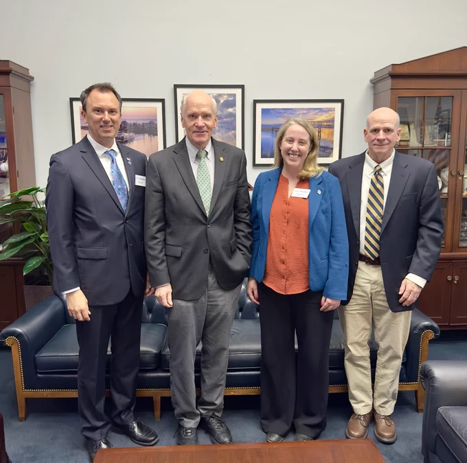 Four people stand together in an office. From left to right, Matthew Charette, Bill Keating, Abigail Archer, and Rob Vincent.