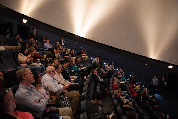 Event photo from AIMLX26. Image depicts a wide-shot of the audience seated in the planetarium. 