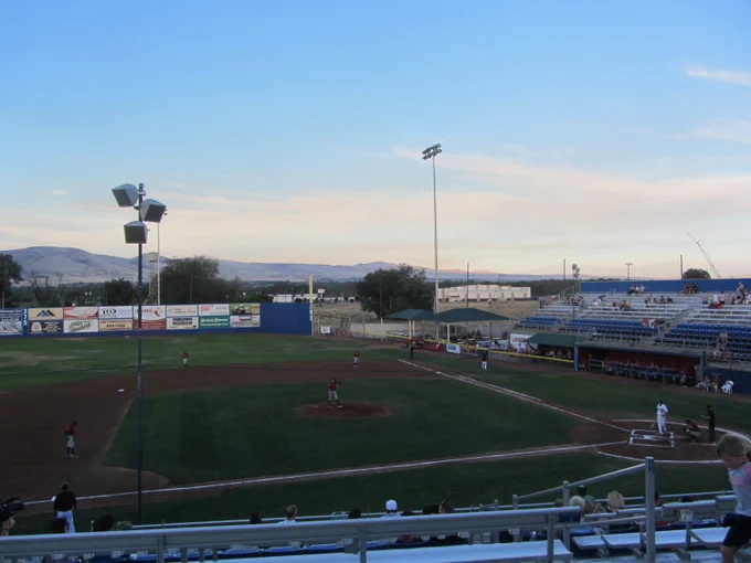 Photo: View of nearly empty baseball stadium under a big, blue sky