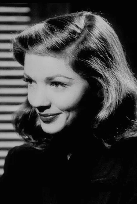 A stylised monochrome 'noir' painting of Hollywood icon Lauren Bacall, using chiaroscuro lighting to capture her classic features. Painted in high-contrast  to recreate a vintage cinematic style.