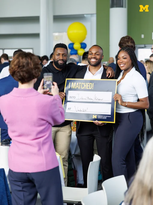 A U-M Medical School Student with a sign that says they matched into internal medicine/pediatrics at Vanderbilt.