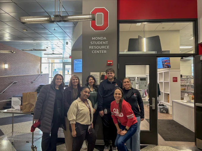 The A&P volunteers smile below the resource center sign.