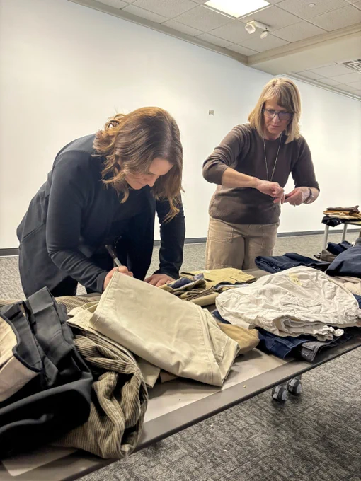 Two volunteers label clothing.
