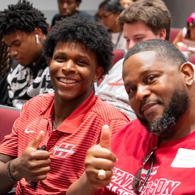 A male student and a family member giving thumbs-up at Heart Start at Henderson State University. 