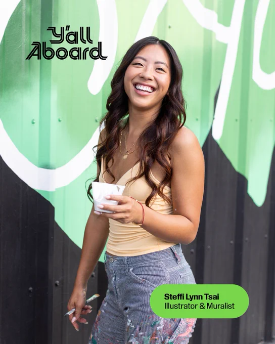 Illustrator and muralist Steffi Lynn Tsai poses near one of her murals with text above that reads “Y’all Aboard.”