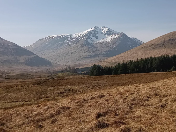 Snowy mountain above a sunny glen